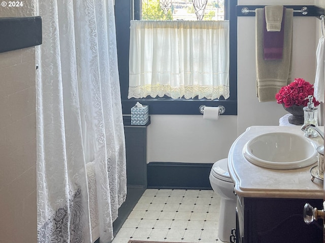 bathroom with a shower with curtain, vanity, toilet, and tile patterned floors