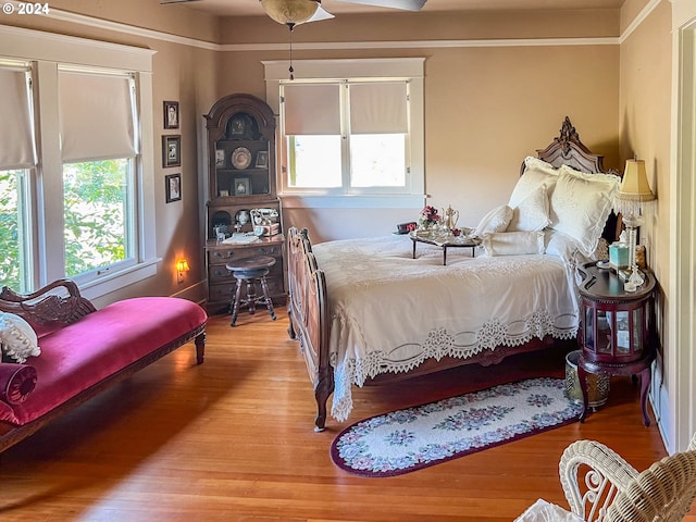 bedroom with light hardwood / wood-style flooring, ceiling fan, and multiple windows