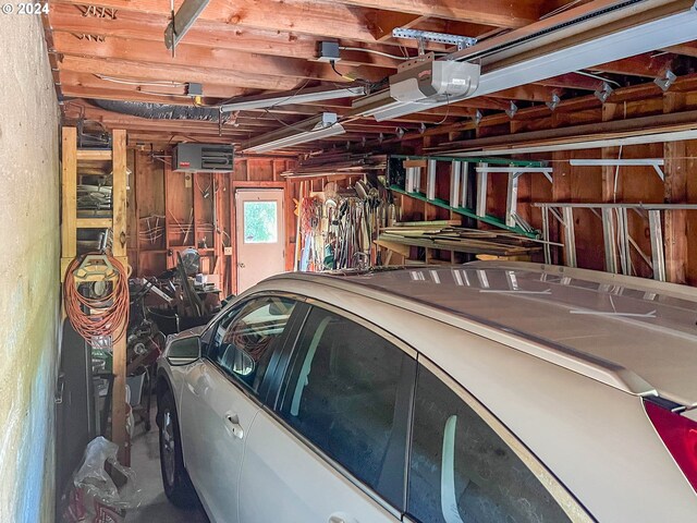 garage featuring a garage door opener and wooden walls