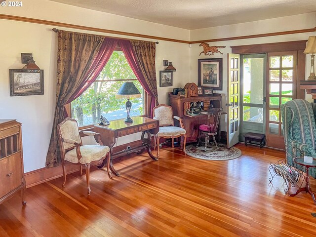 living area with a textured ceiling and wood-type flooring