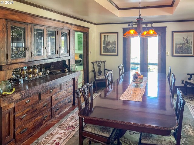 dining space featuring a tray ceiling, ornamental molding, and an inviting chandelier