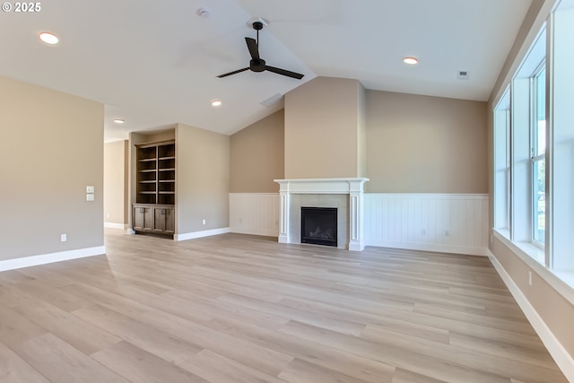 unfurnished living room featuring ceiling fan, lofted ceiling, light wood-type flooring, and a fireplace