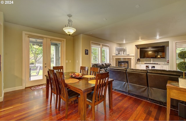 dining space with a fireplace, french doors, and dark hardwood / wood-style flooring