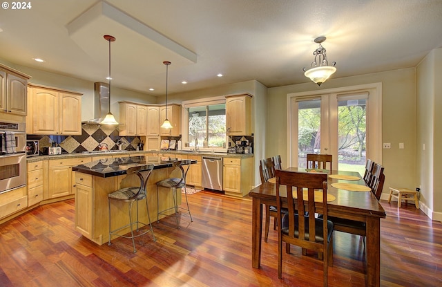 kitchen featuring decorative light fixtures, a kitchen island, and a healthy amount of sunlight