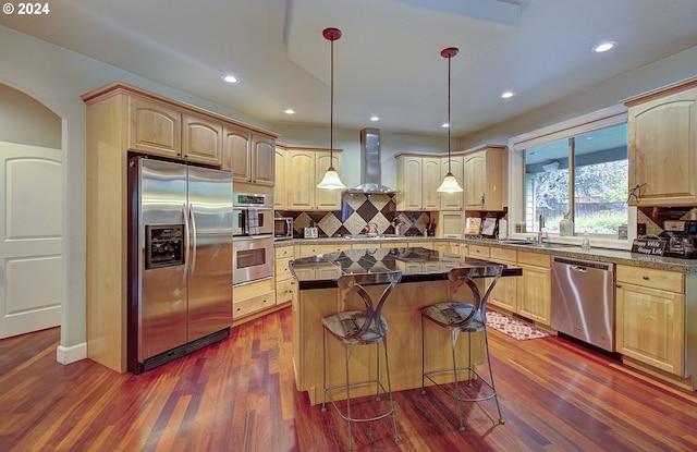 kitchen featuring stainless steel appliances, ventilation hood, pendant lighting, a center island, and dark hardwood / wood-style floors