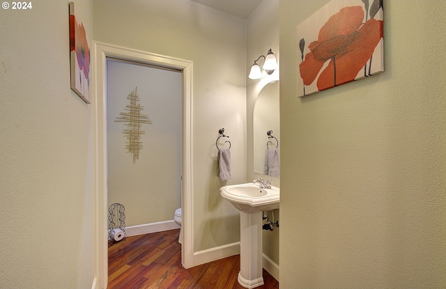 bathroom with wood-type flooring and toilet