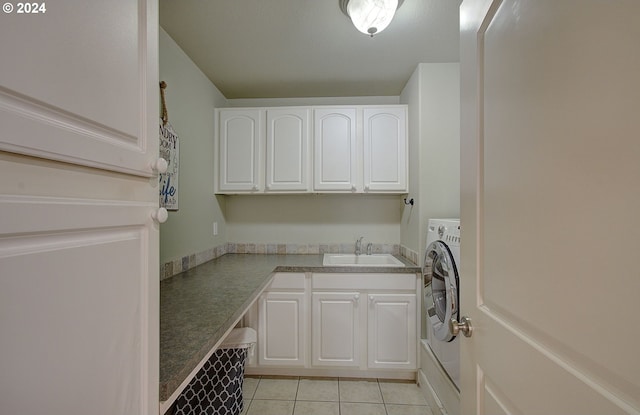 clothes washing area featuring cabinets, washer / dryer, light tile patterned floors, and sink