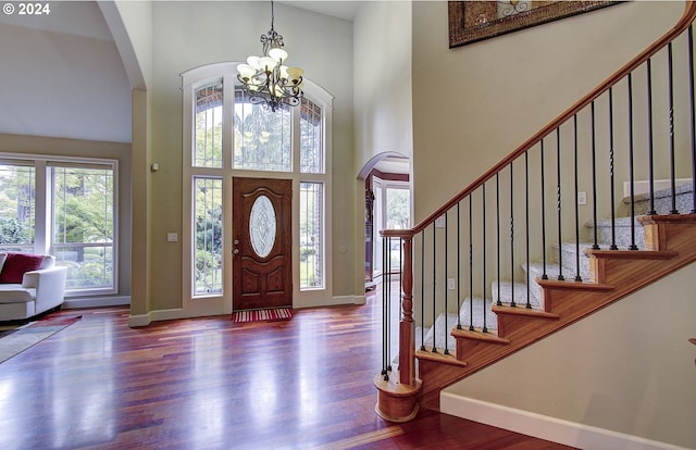 foyer featuring hardwood / wood-style flooring, a notable chandelier, and a towering ceiling