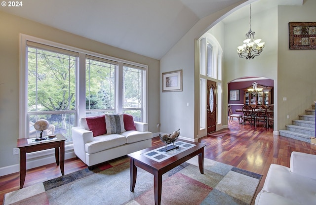 living room with hardwood / wood-style floors, lofted ceiling, and a chandelier