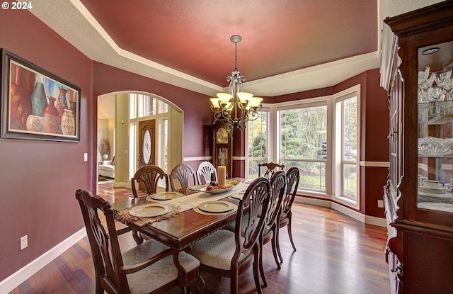 dining room with hardwood / wood-style floors, a textured ceiling, and an inviting chandelier