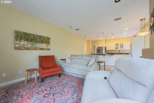 living room featuring light wood finished floors, visible vents, recessed lighting, and baseboards