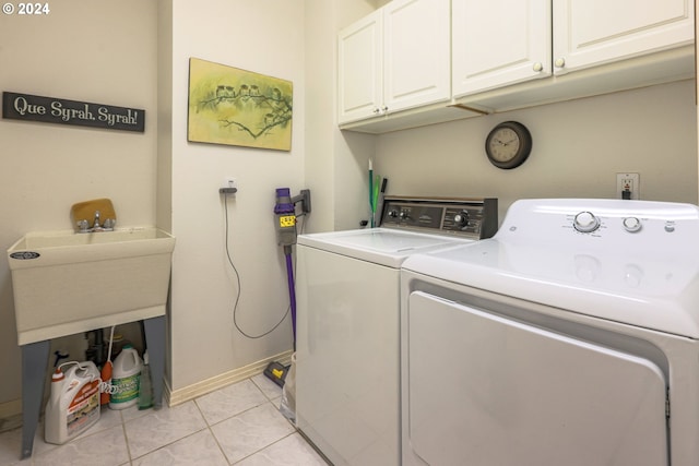 laundry area with light tile patterned flooring, cabinet space, baseboards, and washing machine and clothes dryer