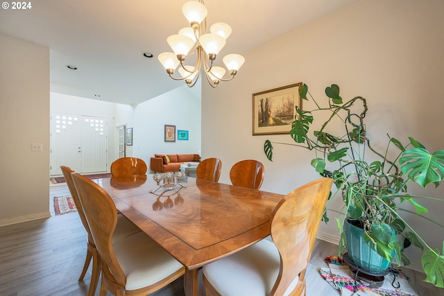 dining room with a chandelier, baseboards, and wood finished floors