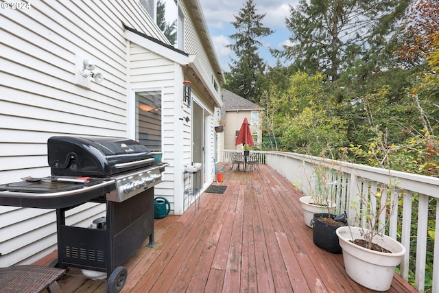 deck with outdoor dining area and a grill