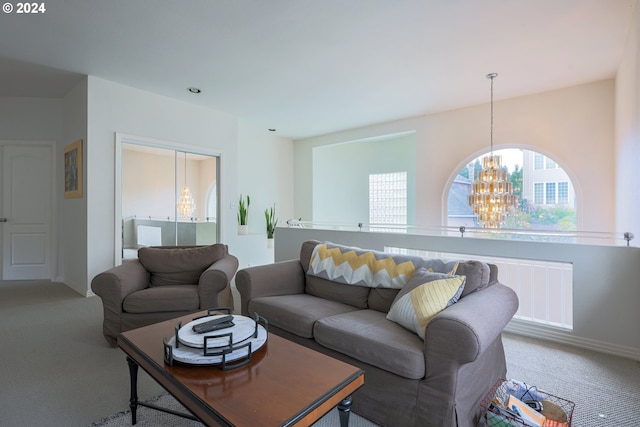 carpeted living room with baseboards and a notable chandelier