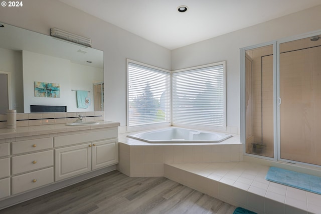 full bathroom featuring vanity, a garden tub, wood finished floors, and a shower stall