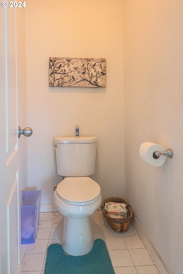 bathroom featuring tile patterned floors, baseboards, and toilet