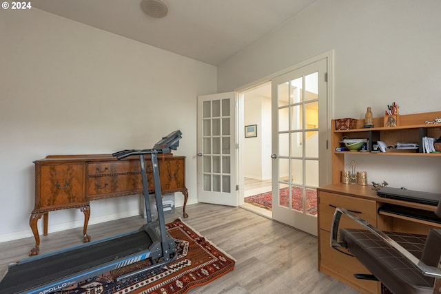 workout room with french doors, baseboards, and light wood-style floors