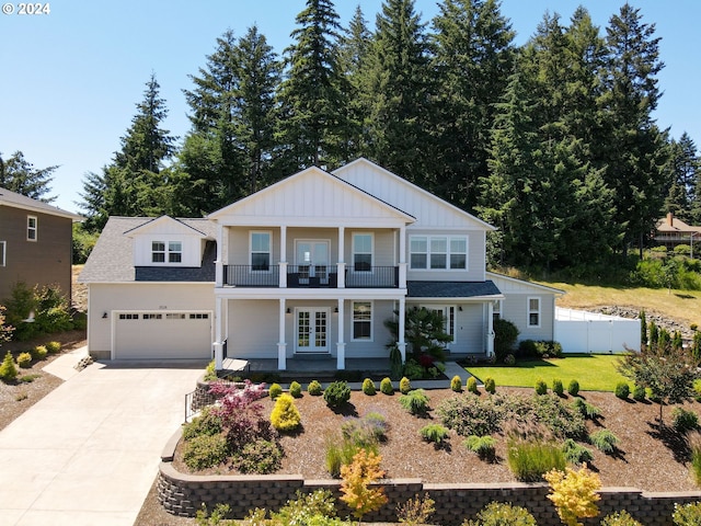 view of front of house with french doors, a balcony, a front lawn, covered porch, and a garage