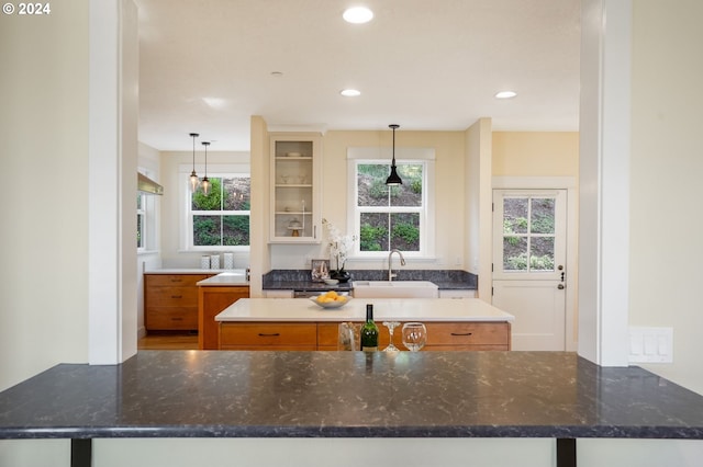 kitchen featuring dark stone counters, a center island, and pendant lighting