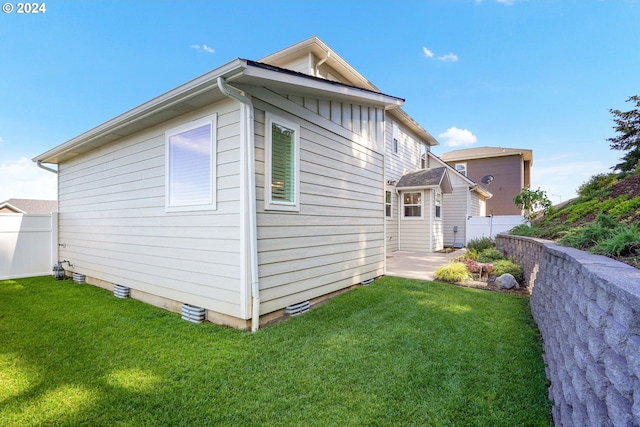 view of side of property with a lawn