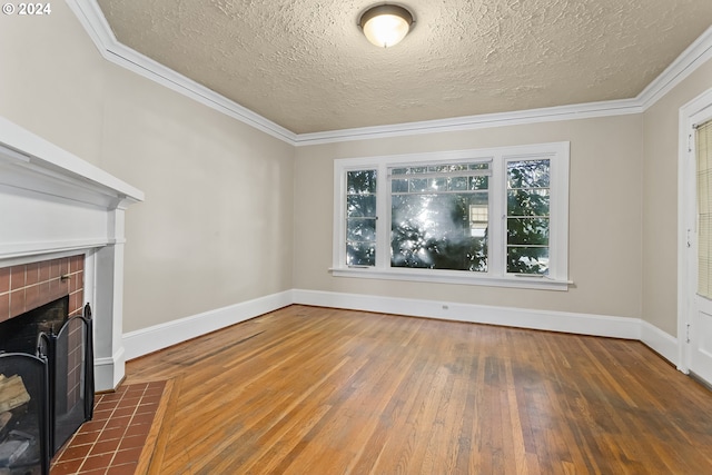 unfurnished living room featuring a tile fireplace, a textured ceiling, dark hardwood / wood-style floors, and crown molding