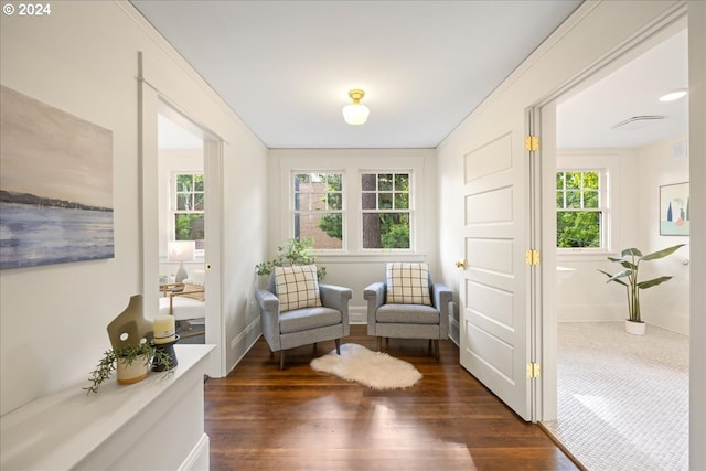 sitting room with plenty of natural light and dark hardwood / wood-style flooring