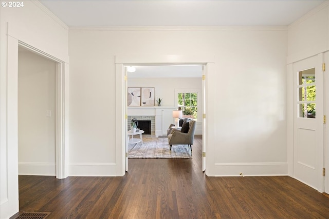 foyer featuring crown molding, a fireplace, and dark hardwood / wood-style floors