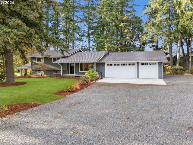 view of front of home with a front yard and a garage