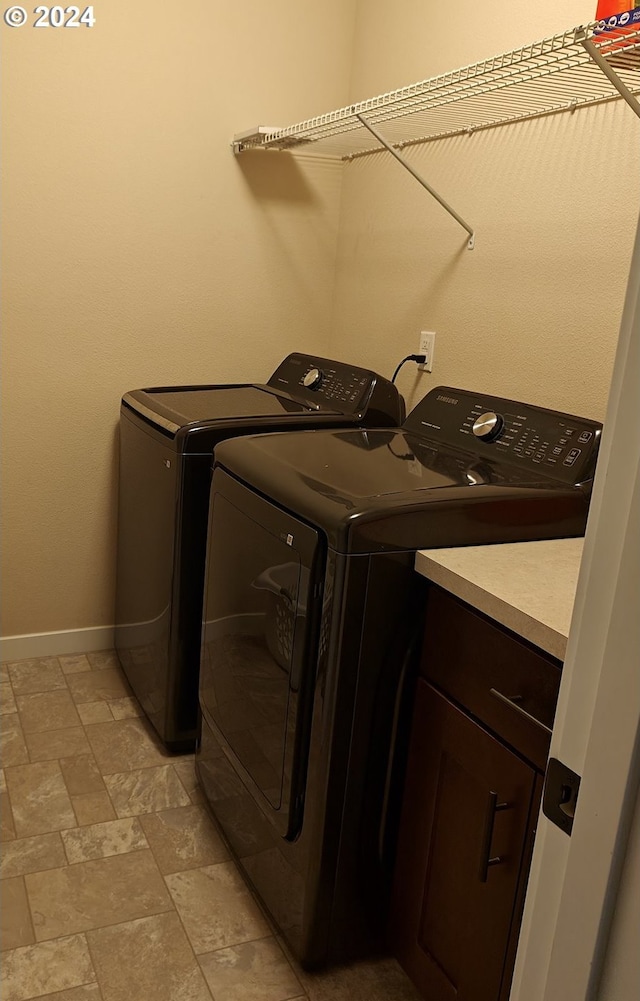 clothes washing area featuring cabinets and independent washer and dryer