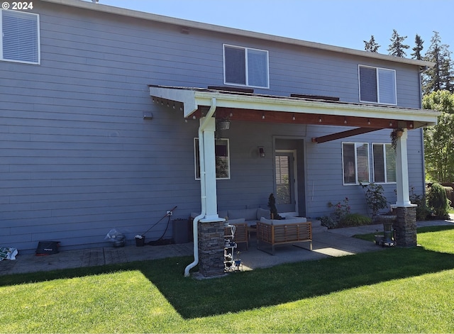 back of house with a patio area and a yard