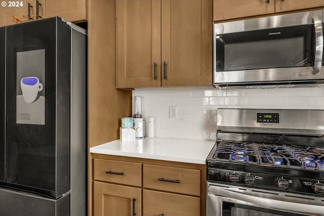 kitchen with appliances with stainless steel finishes and backsplash