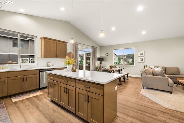 kitchen featuring dishwasher, sink, hanging light fixtures, vaulted ceiling, and light wood-type flooring