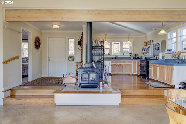14115 N Bank Rd, Roseburg, OR 97470 - kitchen with plenty of natural light, a wood stove, ornamental molding, light tile patterned flooring, and hanging light fixtures