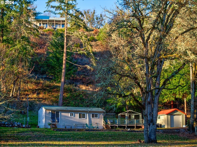 14115 N Bank Rd, Roseburg, OR 97470 - view of front of property featuring an outbuilding, metal roof, a deck, and a front yard