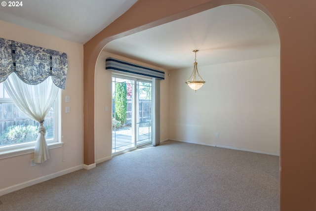 carpeted empty room featuring lofted ceiling and a healthy amount of sunlight