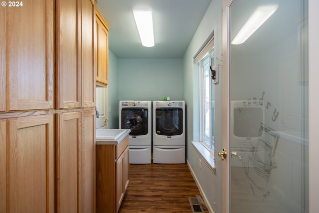 laundry room featuring cabinets, dark wood-type flooring, and washing machine and dryer