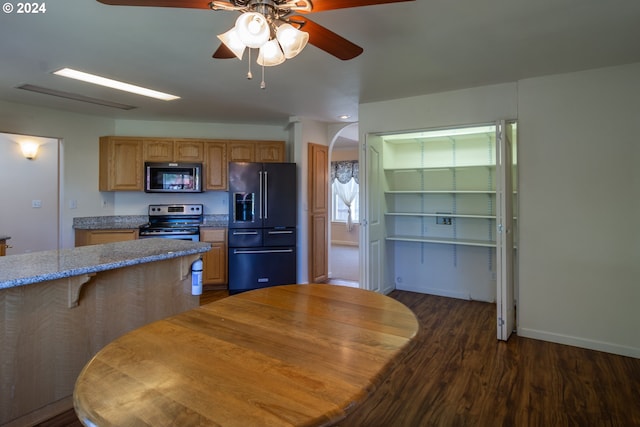 kitchen with light stone counters, black appliances, ceiling fan, and dark hardwood / wood-style flooring