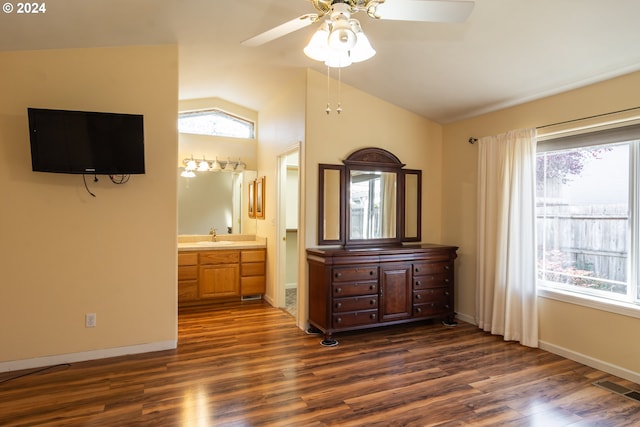 unfurnished bedroom with ensuite bathroom, lofted ceiling, multiple windows, and dark hardwood / wood-style flooring