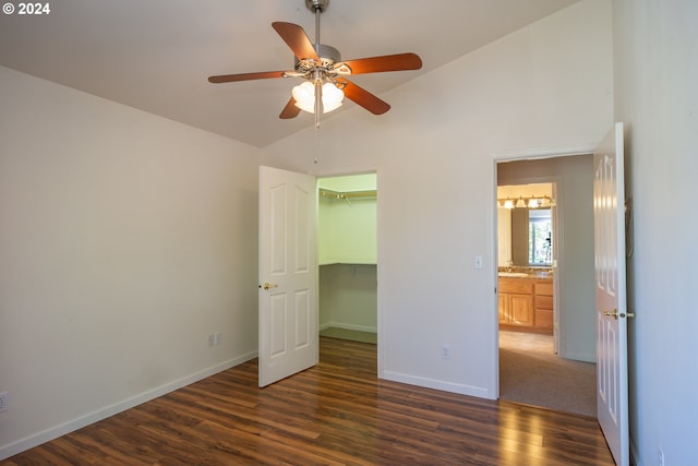 unfurnished bedroom featuring a spacious closet, dark hardwood / wood-style flooring, a closet, ceiling fan, and lofted ceiling