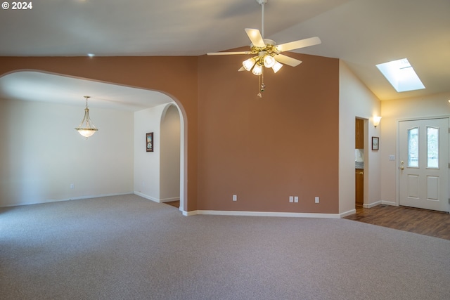 interior space featuring lofted ceiling with skylight, wood-type flooring, and ceiling fan