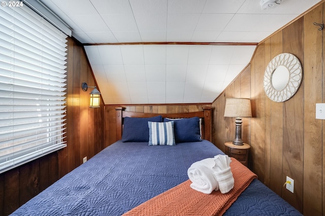 carpeted bedroom with wood walls and lofted ceiling