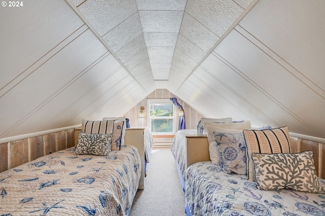 carpeted bedroom with lofted ceiling and wooden walls