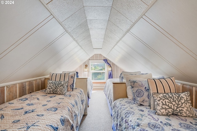 bedroom featuring wooden walls, lofted ceiling, and carpet