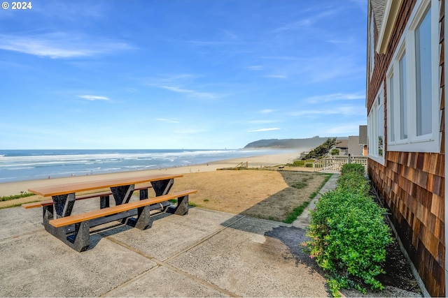 exterior space featuring a view of the beach, a patio, and a water view