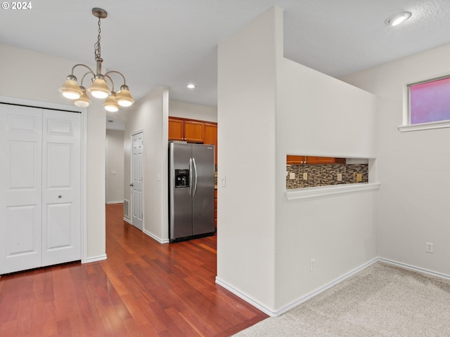 kitchen featuring dark wood-type flooring, an inviting chandelier, stainless steel refrigerator with ice dispenser, and decorative light fixtures