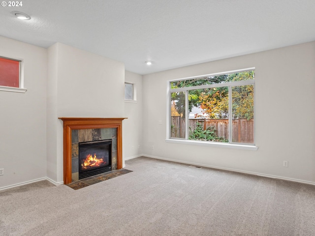 unfurnished living room with carpet, a textured ceiling, and a fireplace