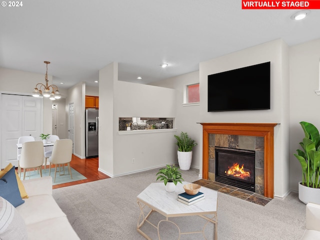 living room featuring a tile fireplace and carpet flooring