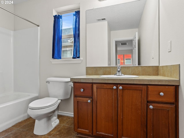 full bathroom with shower / bathtub combination, vanity, a textured ceiling, tile patterned flooring, and toilet