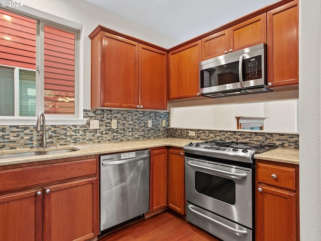 kitchen featuring stainless steel appliances, dark hardwood / wood-style floors, sink, and tasteful backsplash